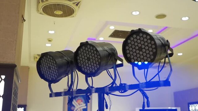 Close-up footage of colorful LED stage lights illuminating an indoor wedding venue. Ideal for themes related to entertainment, event production, stage technology, and venue decoration.