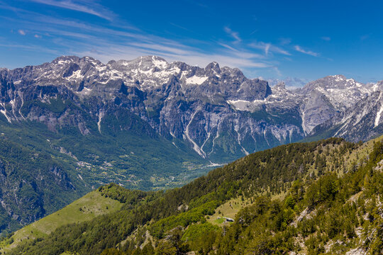 Mountain landscape in the Albanian Alps near Theth, Albania. Theth Valbona valley trek Peaks of the Balkans scenic way. Rugged peaks rise above forested valleys and alpine meadows