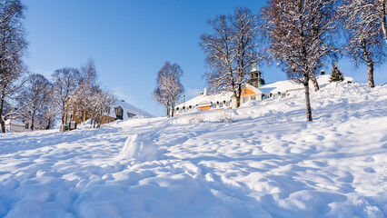 Red house and snowy forest below Arctic mountains in Tromso © lee