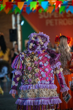 Rio de Janeiro, Brazil - 20 June 2026: View of a performer in a vibrant, floral-patterned costume at a Festa Junina celebration, with intricate lace details and colorful bunting.