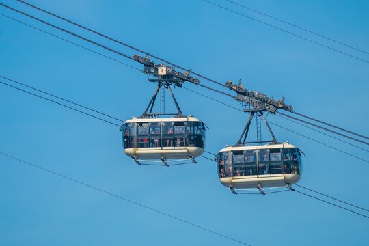 Rio de Janeiro, Brazil - 19 June 2026: View of the Sugarloaf Mountain cable cars transporting passengers against a clear blue sky.