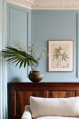Obraz premium Living room corner featuring a dark walnut mantelpiece with a decorative vase of flowers and a botanical print on the blue wall, creating a serene interior design aesthetic
