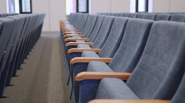 Uniform rows of comfortable conference furniture in lecture hall. Clean layout provides organized and structured academic environment