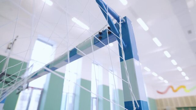 Sports hall features soccer goal structure with woven safety netting. Clean gym design provides highly motivating space for team games