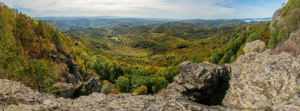 Aerial view of Sitno mountain in Stiavnicke Vrchy, featuring rugged rock formations, dense autumn forests with vibrant foliage, and rolling hills in Ilija, Banska Bystrica Regio, Slovakia.
