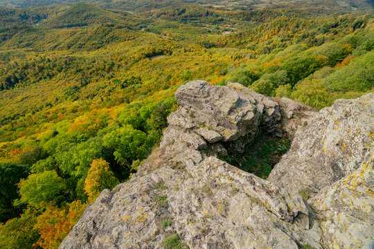 Aerial view of Sitno in Stiavnicke Vrchy with rocky cliffs overlooking the vibrant autumn forest canopy in Ilija, Banska Bystrica Region, Slovakia.