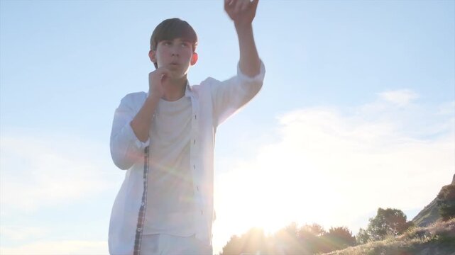 Medium shot of a young athlete practicing boxing training on a beach at sunset. Teenage boxer throwing jabs and dodging punches in slow motion during an outdoor fitness workout by the sea.