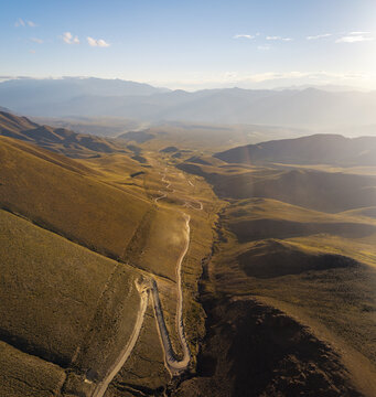 Aerial view of the winding road leading towards the Hornocal mountain range in the arid landscape of Humahuaca, Jujuy Province, Argentina.