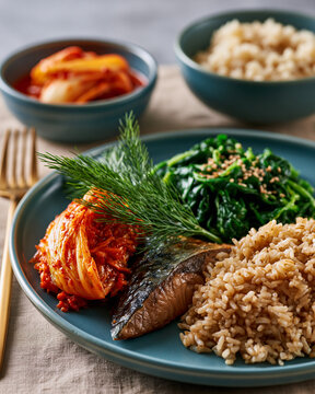 Minimal blue ceramic plate with kimchi mackerel spinach namul and brown rice showcasing Korean wellness longevity and anti inflammatory nutrition