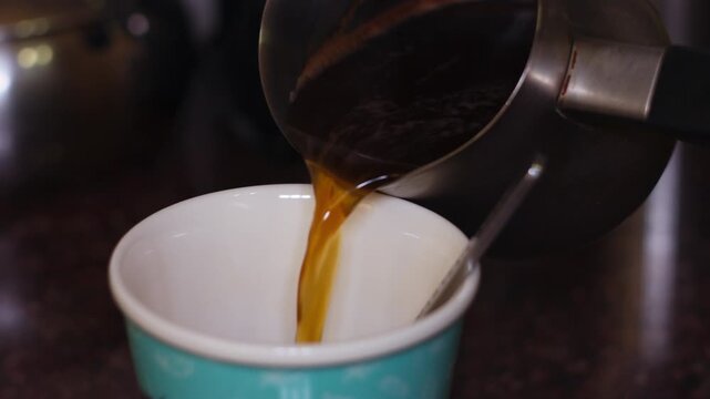 Close-Up of Fresh Hot Coffee Being Poured into a Colorful Decorative Cup