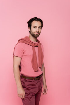 Stylish man showcases summer fashion with an authentic smile against a vibrant background