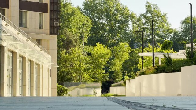 A modern apartment complex stands in a lush green park in Simferopol, Crimea. This serene environment creates a calm and inviting atmosphere. It feels like a peaceful place to live.