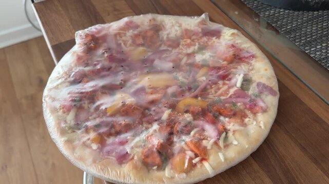 Frozen Pizza Wrapped in Plastic Representing Unhealthy Processed Convenience Food