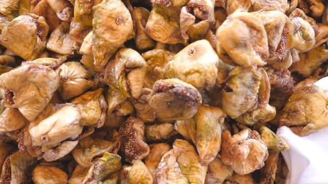 Detail view on pile of dried figs. Close up of falling sweet and tasty berries. Healthy food concept. Slow motion Top view