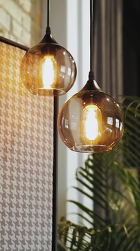 Vertical video. Two pendant lights illuminate modern interior with warm ambient lighting.