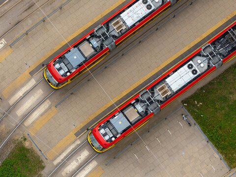 Aerial view of two red and yellow trams parked at the tram depot in Warsaw, Masovian Voivodeship, Poland.