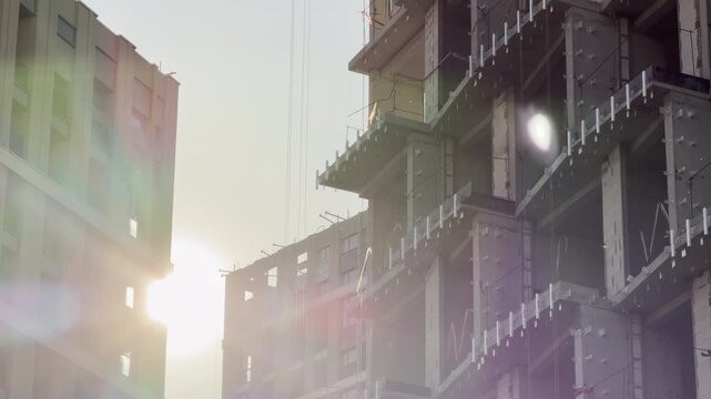 A skeletal building frame rises beside a completed tower in Simferopol, Crimea. Golden sunbeams create a hopeful, radiant atmosphere, capturing the inspiring energy of ongoing urban development.