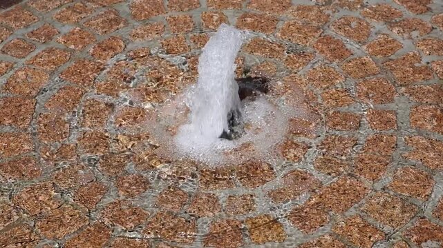 Water jet bubbling up from a fountain in super slow motion