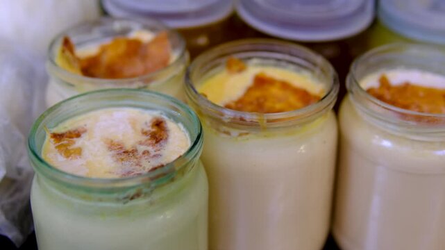 homemade fermented baked milk in half-liter jars on the market. Homemade fermented dairy beverage rich in probiotics featuring kefir buttermilk and yogurt