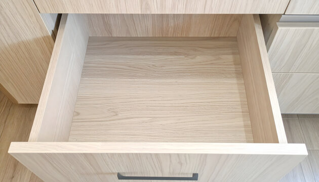 Empty light wood drawer pulled out from modern cabinet