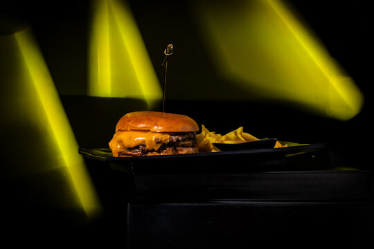 Gourmet double cheeseburger served with chips, focusing on food experience and small business