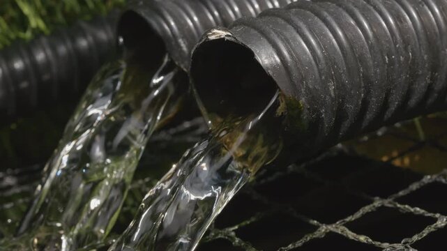Water flowing into a garden pond from a filter stock footage