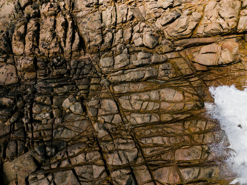 Aerial view of the rugged rock formations at Injidup Natural Spa, with crashing ocean waves hitting the coastline Yallingup, Western Australia, Australia.