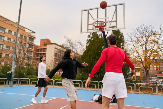 Young men playing basketball on urban court