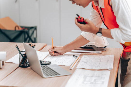 Person Working with Technical Equipment and Documents at Desk