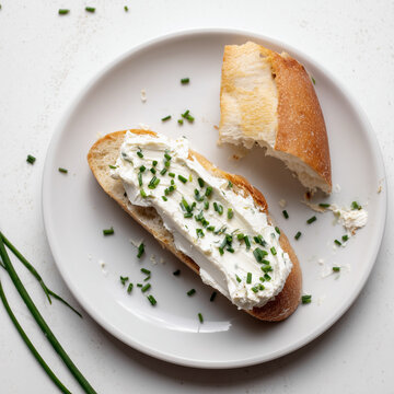 Frisches Baguette mit Kr&auml;uterfrischk&auml;se und Schnittlauch. Einfaches Food-Motiv f&uuml;r Fr&uuml;hst&uuml;ck, Brotzeit, Abendbrot, regionale K&uuml;che und hausgemachten Genuss.