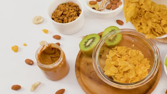 Pouring Golden Corn Flakes into Glass Bowl for Healthy Breakfast