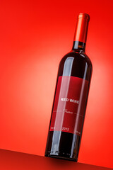 Fototapeta premium Red wine bottle mockup on red background