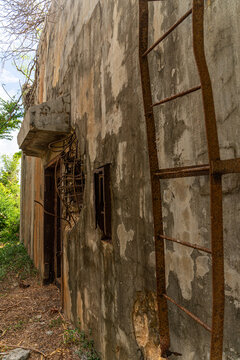 View of the weathered concrete wall of the historic North Field Base with a rusted metal ladder and exposed rebar in Northern Tinian, Tinian, Northern Mariana Islands.