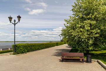 Fototapeta premium Bench on waterfront promenade with river view
