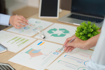 Obraz premium Cropped hands of businesspeople analyzing ESG charts for corporate sustainability strategy
