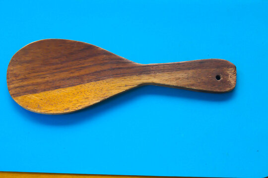 Wooden Rice Paddle on Blue Background with Minimalist Design
