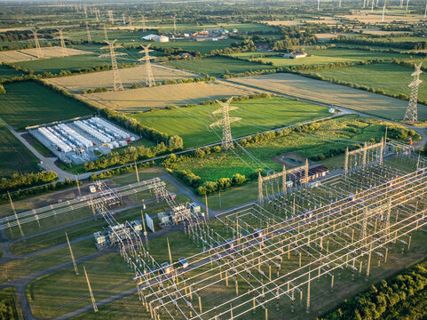 Aerial view of high-voltage electrical substation integrated with a large containerized battery energy storage system (BESS).