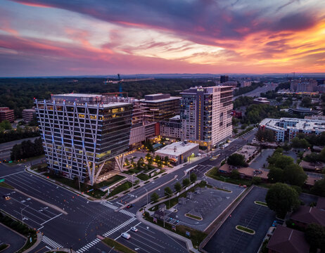 Reston, Virginia, United States - 27 May 2020: Aerial view of modern office buildings and mixed-use developments at sunset with a vibrant sky.