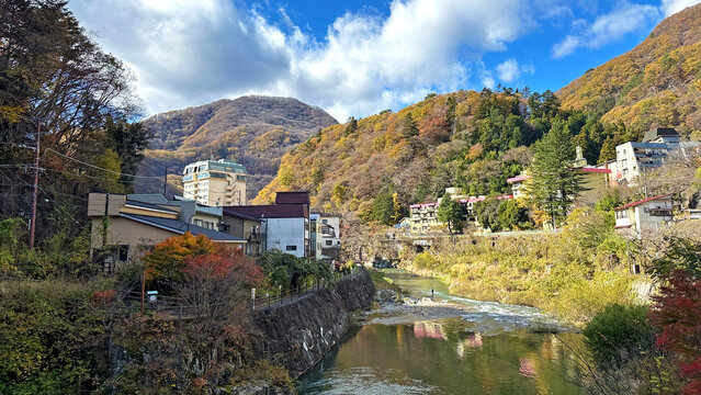 栃木県日光市の川治温泉付近を流れる川と美しい山々の紅葉風景