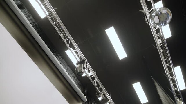 Stage equipment includes theater projectors hanging lamps and drapes. Structured setup provides excellent illumination for school events