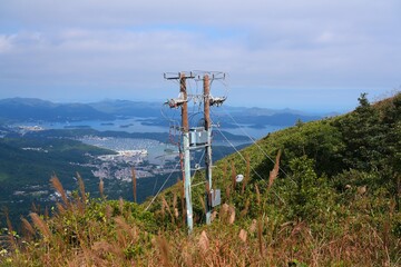 Fototapeta premium Electric line wooden pole with transformer. Electric grid infrastructure in Kowloon Peak area of Hong Kong, China.