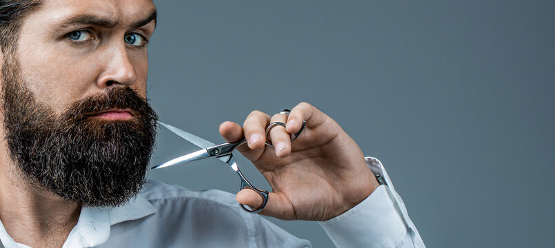 Barber scissors, barbershop in a white shirt. Barber scissors. Vintage barbershop. Barber scissors, barber shop. Portrait of stylish professional hairdresser with beard. Man holding scissors.