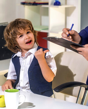 Business boy. Little boss in the office, businessman. Young businessman using a laptop. Funny homeschooling for kids