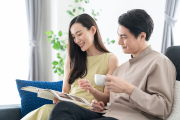Obraz premium リビングで読書をするミドルの夫婦