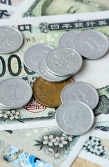 Japanese yen money bills and coins on table. Japan cash of JPY currency close up © Larysa