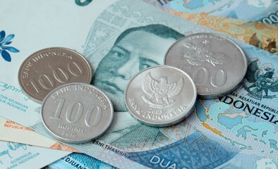 Indonesian rupiah money bills and coins on table. Indonesia cash of IDR currency © Larysa