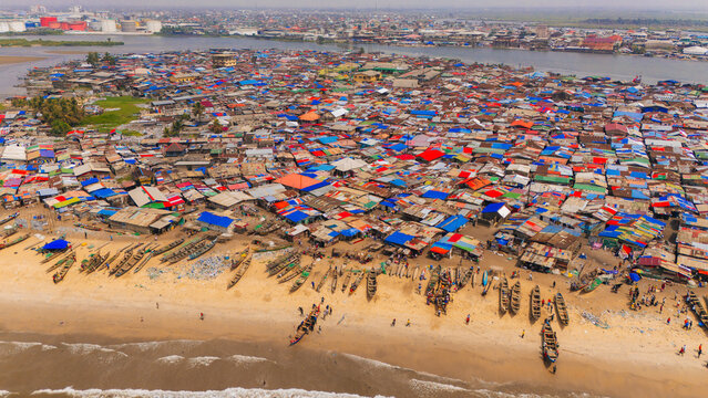Monrovia, Liberia - 19 June 2026: Aerial view of West Point, a densely populated coastal neighborhood with tightly packed corrugated metal rooftops and wooden fishing boats on the sandy beach.