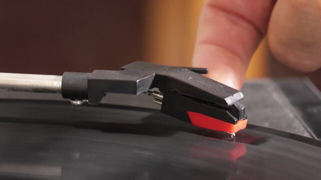hand finger setting a vinyl record in motion