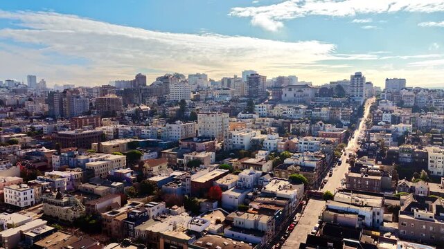 San Francisco residential district with Victorian housing, California. Dense low rise neighborhood, colorful mixed facade, grid street pattern converging toward downtown skyline and hazy bay beyond.