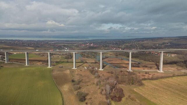 In Hungary's Somogy County, the Kőr&ouml;shegyi V&ouml;lgyh&iacute;d carries M7 highway traffic across a rural landscape of winter fields and woodland, captured in a sideways tracking drone view.